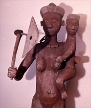 Large figure of a woman with the attributes of a chieftainess, used to surmount the roof of a chiefs hut