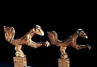 Two gold birds, probably chair decorations