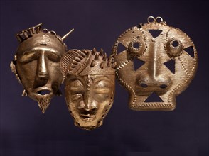 Gold pendants in the form of a stylized heads