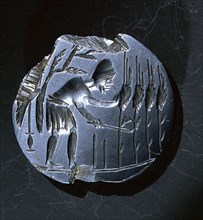 Intaglio amulet showing a reaper stooping to cut corn
