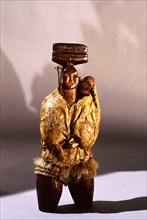 Woodcarving of an East Greenland woman carrying a baby in the back of her parka