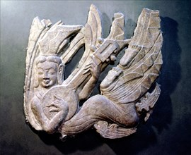 Architectural detail showing a flying apsara (celestial being) playing a musical instrument