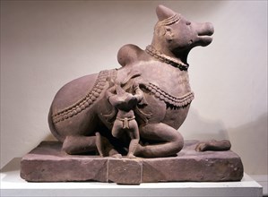 Free standing statue of Nandi, the bull mount of Shiva with attendant tying a garland around his neck
