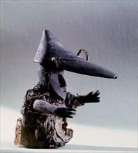 A small figure of a man wearing a wooden hunting hat