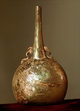 A glass flask with gold iridescent surface