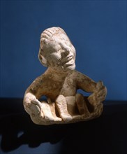 Terracotta figure of a man holding a model boat