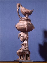 A Senufo seated female figure surmounted by a bowl and a bird