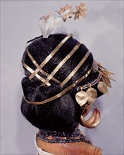 Mounted on a model are hair ornaments, earrings and necklaces