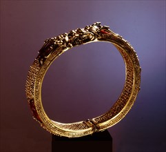 Gold filigree bracelet with cornelians and terminals in the form of a pair of facing dragon heads