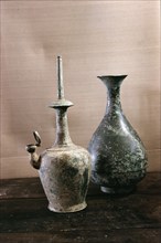 A carafe, and a ritual water vessel of unglazed, high fired, dark grey stoneware