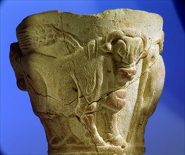 A stone cup decorated with bulls and ears of corn in raised relief