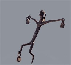 An altar iron in the form of a stylized dancing figure