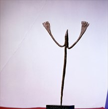 An altar iron in the form of a stylized figure with upraised arms