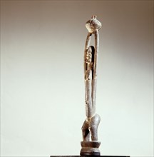 A Dogon sculpture with upraised arms holding a bowl