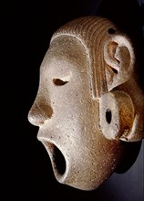 Open mouthed stone mask of Xipe Totec, the Flayed Lord, dressed in the skin of a sacrificial victim