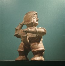 Standing ithyphallic figure, holding phallus