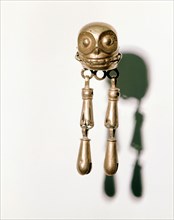 Earring composed of a gold skull from which hang tiny bells