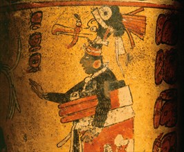 Cylindrical vessel decorated with date glyphs and a Mayan ball player wearing black body paint and heavy padding for the competition