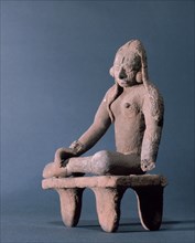 Figurine of a woman sitting on a stool