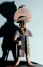 Figurine of a man wearing a large hat, possibly a priest