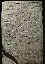 Relief from the stela 10 depicting a ruler holding the hair of a prisoner who kneels in supplication in front of him