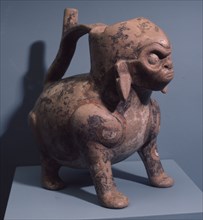 A painted ceramic dog vessel, with human head or wearing a human mask