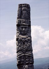 The upper section of a stele showing Quetzalcoatl wearing his traditional cone shaped hat, a necklace, earrings and, on his chest, the wind jewel