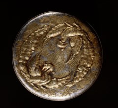 The reverse of a mirror decorated in relief with a pair of phoenixes