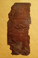 Face, possibly a portrait, embossed in copper