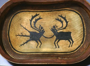Bentwood serving dish with a bull caribou (right) linked to its spiritual counterpart, which is identified as such by its strange appendages
