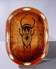 Serving bowl which has been dyed red and painted with a mythological creature
