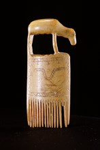 Comb with incised design and decorated with an animal form