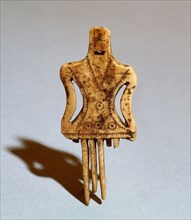 Comb in the shape of a stylized female figure with incised decorations