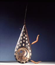 A mask with two arms missing and a humorous face composed of whirling crescent shapes