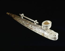 Elegantly carved and decorated pipe which carries its own cleaner in rings attached to the top
