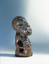 Small seated Maori figure, probably the footrest from a ceremonial digging stick