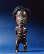 Carved wooden human figure with inlaid metal eyes and human hair
