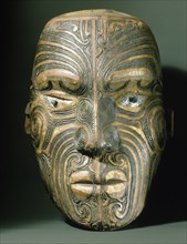 A carved wood Maori head with inlaid shell eyes