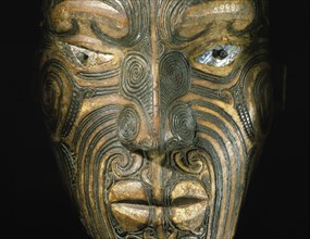 A carved wood Maori head with inlaid shell eyes
