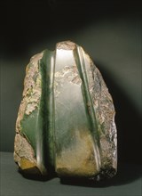 A block of jade with an adze blade, of the form used for a tokipoutangata, ceremonial chiefs axe, partially carved out