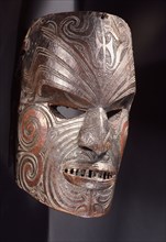 A carved hardwood mask (mata rahui) with pierced eyes and mouth