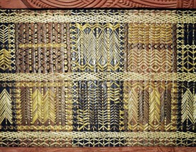 Reed latticework panels woven by women alternated with the carved wooden ancestor figures along the side wall of meeting houses
