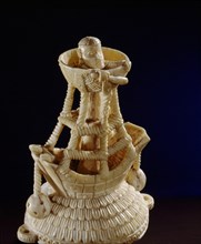 Detail of the lid of an ivory salt cellar around the base of which are figures of Portuguese noblemen