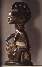 A wooden maternity figure, probably given as a thanksgiving offering to an orisha shrine following successful prayers for a child