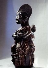 A shrine figure for Orisha Oko, the deity associated with farming, depicting a woman with a multitude of children