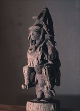 A shrine figure depicting a warrior in the full battle dress of the 19th century, Yoruba wars carried on the shoulders of a retainer