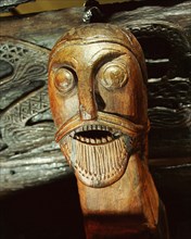 Fierce human mask carved on the side of the Oseberg cart