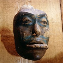 A mask representing a woman wearing a labret