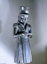 Argillite figure of a British or American sea captain in hat and dress coat holding a closed book