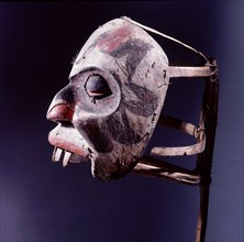 This large mask on a stick frame was worn strapped to the back of the incumbent of the family name Torch lights